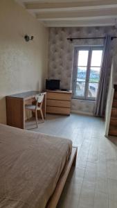 シノンにあるVaste appartement avec vue sur la Vienneのベッドと机と窓のある寝室
