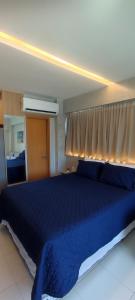 ein Schlafzimmer mit einem blauen Bett mit blauer Decke in der Unterkunft Flat Makia Beach Muro Alto, Porto de Galinhas in Ipojuca