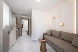 a living room with a couch and a table at Opalium Beach Front Suites in Potos