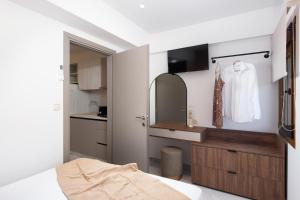 a bedroom with a bed and a dresser with a mirror at Opalium Beach Front Suites in Potos