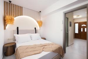 a bedroom with a large white bed with white pillows at Opalium Beach Front Suites in Potos
