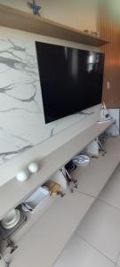 einen Flachbild-TV auf einer Theke in der Unterkunft Flat Makia Beach Muro Alto, Porto de Galinhas in Ipojuca