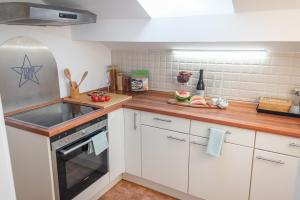 a kitchen with white cabinets and a stove top oven at La Casa Bonita in Bad Aibling +47 photos