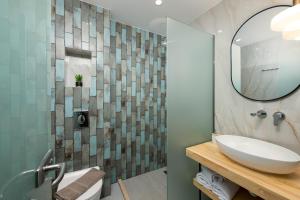 a bathroom with a sink and a mirror at Opalium Beach Front Suites in Potos