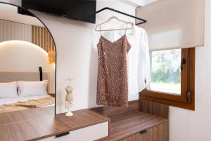 a bedroom with a dress hanging on a mirror at Opalium Beach Front Suites in Potos