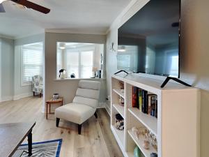 a living room with a chair and a book shelf at Smiling Jacks Escape in Mustang Beach