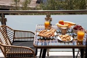 a table with a tray of food and a bowl of fruit at Opalium Beach Front Suites in Potos