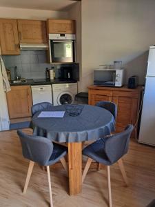 a kitchen with a table and chairs in a kitchen at Appartement tout confort in Brides-les-Bains