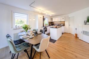 a kitchen and dining room with a table and chairs at Fewo Resaleen in Öhningen