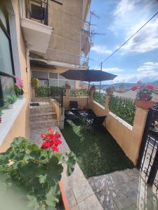 a balcony of a building with a table and an umbrella at Spitaki Kastoria Apartment in Kastoria