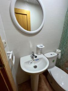 a bathroom with a sink and a mirror and a toilet at Casa Darío in Ceuta +19 photos
