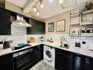 a kitchen with a washer and a washing machine at Spacious and Stylish Flat in the Heart of Hawick in Hawick