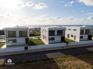dos edificios blancos con el océano en el fondo en Can Sony - Quaint Villa by the Ocean with Pool, en Ericeira