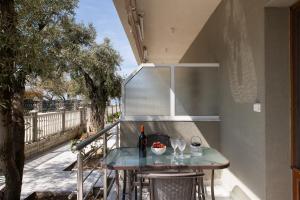 a table on a balcony with wine bottles and glasses at Opalium Beach Front Suites in Potos