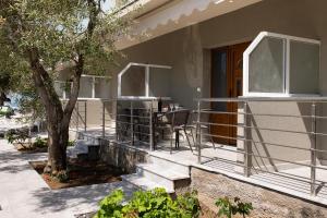 a porch of a house with a table and a tree at Opalium Beach Front Suites in Potos