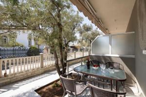 a table and chairs on a balcony with a tree at Opalium Beach Front Suites in Potos
