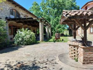an outdoor patio with a wooden pergola at La Martinella in Canelli