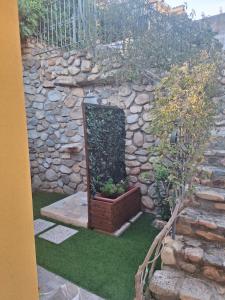 Un muro de piedra con una planta en maceta sobre el césped. en Villetta Chiara, en Costa Rei 29 fotos más