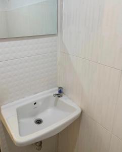 un lavandino bianco in un bagno con uno specchio di brk บีอาร์เค ดอนเมือง เมืองทอง a Bangkok