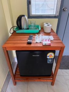 a wooden table with a microwave on top of a table at brk บีอาร์เค ดอนเมือง เมืองทอง in Bangkok
