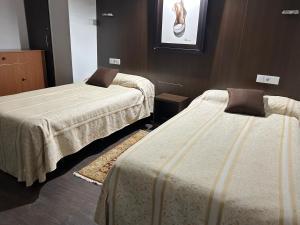 two beds in a hotel room with at EL Hotelito in Alija del Infantado +2 photos