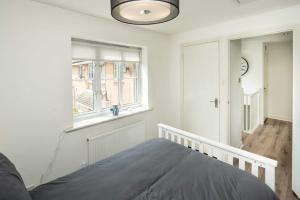 a bedroom with a bed and a window at Loughton Hideaway: Cozy 1BD Near Tube & Nature in Theydon Bois