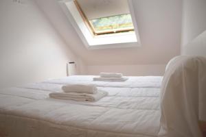 1 dormitorio blanco con 2 toallas blancas en una cama en Apartamentos Terramar, en Boiro