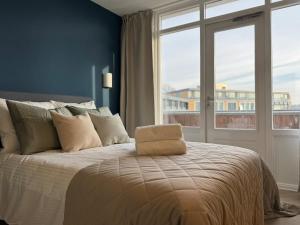 a bedroom with a large bed with a large window at The Charming chic Garden View Den Aprt R2 in The Hague
