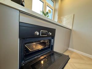 an open oven in a kitchen with a counter at The Charming chic Garden View Den Aprt R2 in The Hague