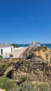 a building on top of a rocky hill next to the ocean at Algarve/Sra da Rocha in Porches