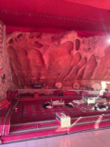 Una habitación con una pared roja con una formación rocosa. en Desert Star Camp, en Wadi Rum 19 fotos más