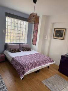 a bedroom with a large bed and a window at GREEN&PURPLE STUDIO 24-24 Access in Bois-Colombes