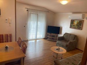 a living room with a couch and a table and a television at Apartments Žitna Sun in Vir