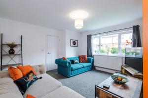 a living room with a blue couch and a window at Stylish 3 Bedroom Home with Driveway, Family and Business Friendly in Mold