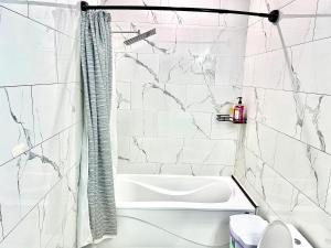 a bathroom with a white tub and marble walls at Private Room In Cambridge B8DW in Cambridge