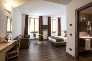 a hotel room with a bed and a bathroom at Hotel Portici - Romantik & Wellness in Riva del Garda