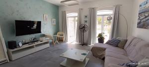 a living room with a couch and a flat screen tv at Azure in Għarb