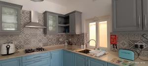 a kitchen with blue cabinets and a sink and a window at Azure in Għarb