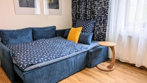 a blue couch in a living room with a table at Suite 13 Van Gogh in Neunburg vorm Wald +18 photos