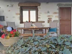 a dining room with a table and chairs and a plant at Traditional house paros in Sarakíniko