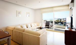 a living room with a couch and a large window at Sitges Apartamente frente al mar con piscina in Sitges