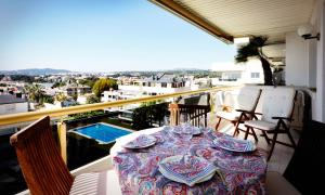a table on a balcony with a view of a city at Sitges Apartamente frente al mar con piscina in Sitges