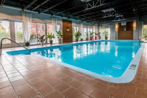 a large swimming pool with blue water in a building at Le Haven in MSA in Beaupré
