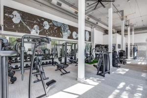 a gym with several tread machines and a mural at Comfy Apartment in Frisco in Frisco