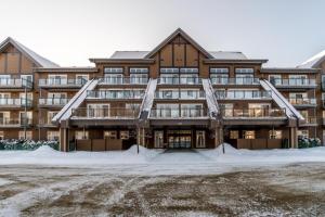 a large building with snow in front of it at Le Haven in MSA in Beaupré