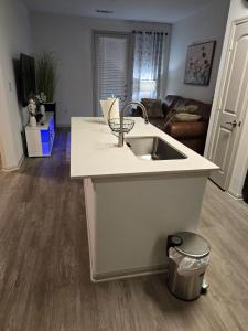 a kitchen with a sink and a living room at Comfy Apartment in Frisco in Frisco