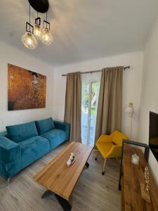 a living room with a blue couch and a table at Poseidon Garden View Apartment in Perivólion