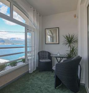 a room with a table and a chair and a window at Rosemary Terrace Krasici in Krasici