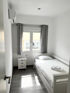 a white bedroom with a bed and a window at Cullera Sea and Mountain Balcony in Cullera