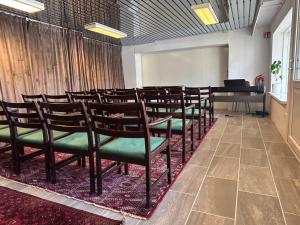 a row of chairs in a room with a piano at Sognefjord Gjesteheim in Vangsnes